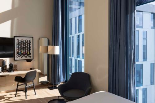 a hotel room with a bed and a desk and chairs at Scandic Hamburg Emporio in Hamburg