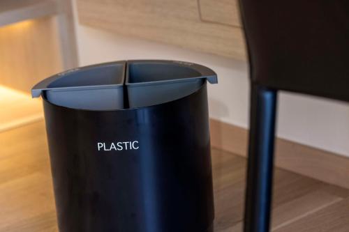 a black trash can sitting next to a chair at Scandic Hamburg Emporio in Hamburg