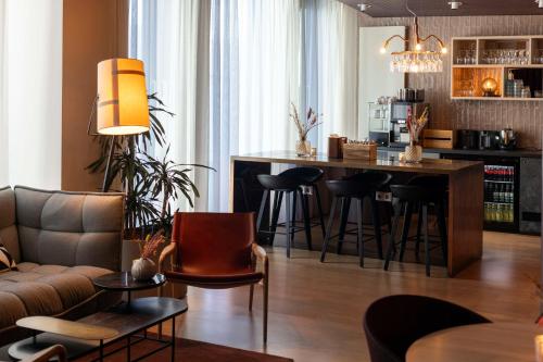 a living room with a bar with stools at Scandic Hamburg Emporio in Hamburg
