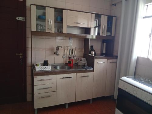 a kitchen with wooden cabinets and a sink at Linda e aconchegante casa in Toledo