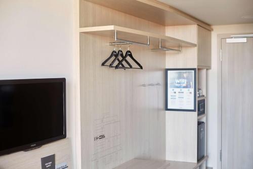 a living room with a flat screen tv and a tv at Scandic Hamburg Emporio in Hamburg
