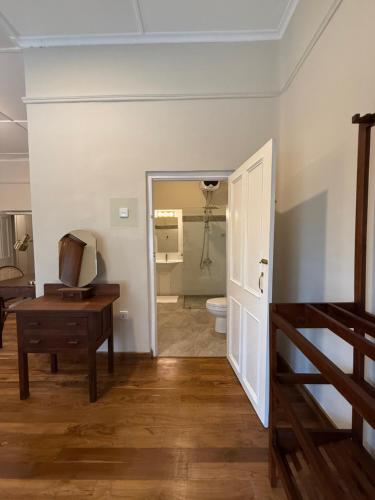 a room with a bathroom with a toilet and a table at Watawala Tea Plantation Bungalow in Rozella