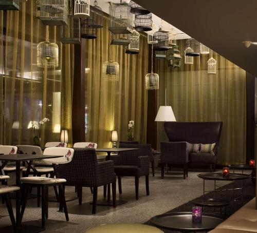 a restaurant with tables and chairs and chandeliers at Scandic Copenhagen in Copenhagen