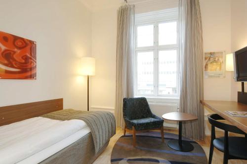 a bedroom with a bed and a desk and a window at Scandic Webers in Copenhagen