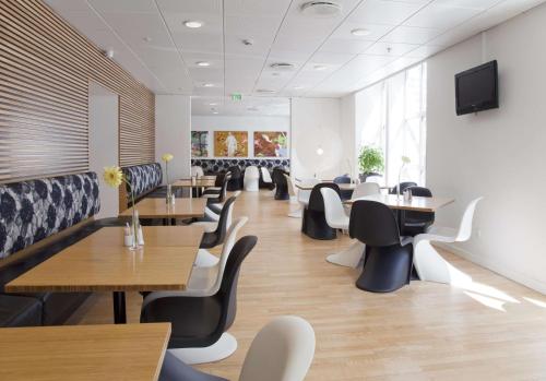 a restaurant with tables and chairs and a flat screen tv at Scandic Webers in Copenhagen