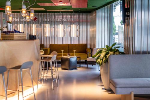 a restaurant with a bar with stools and a table at Scandic Webers in Copenhagen