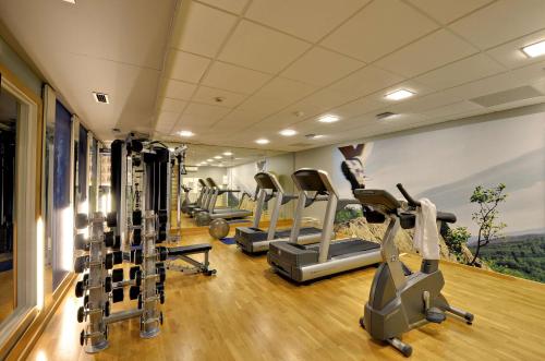 a gym with several treadmills and elliptical machines at Scandic Roskilde Park in Roskilde