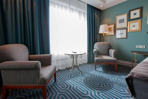 a hotel room with a bed and chairs and a window at Scandic Park Helsinki in Helsinki