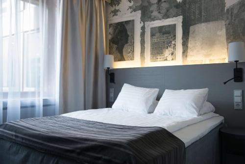 a bed with white sheets and pillows in a bedroom at Scandic Park Helsinki in Helsinki
