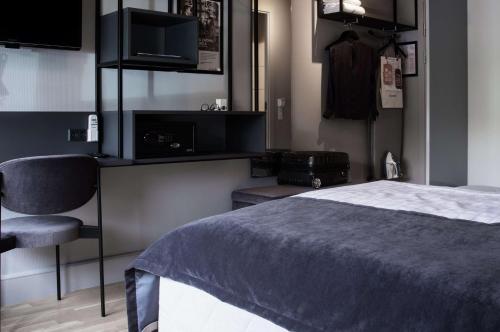 a bedroom with a bed and a tv and a chair at Scandic Odense in Odense
