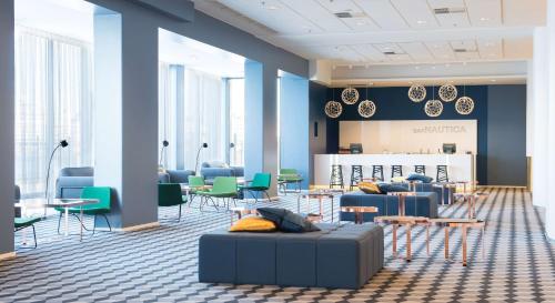 a lobby with a couch and tables and chairs at Scandic Grand Marina in Helsinki