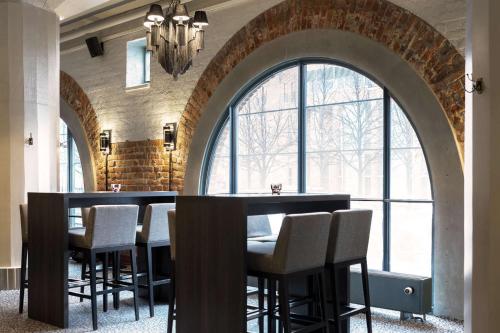 a dining room with a table and chairs in front of a large window at Scandic Grand Marina in Helsinki