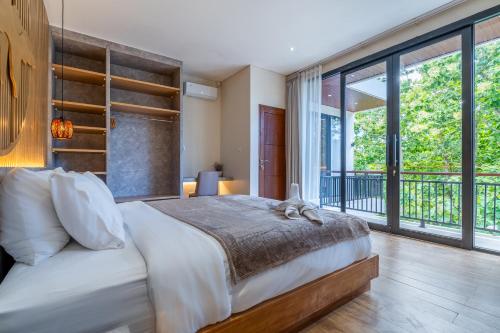a bedroom with a large bed and a balcony at Jobon Villas by Great Bali Villas in Uluwatu