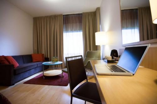 a living room with a laptop computer on a desk at Scandic Oulu City in Oulu