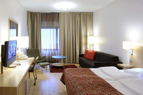 a hotel room with a bed and a couch at Scandic Oulu City in Oulu