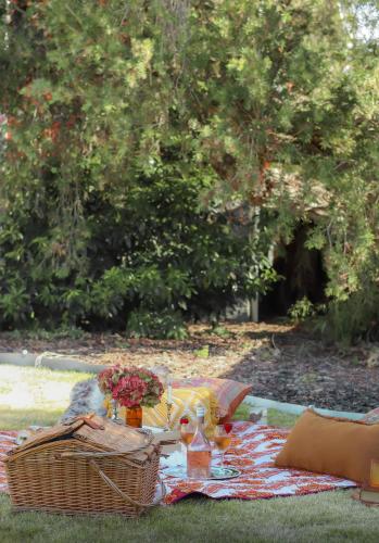 a picnic table with a basket and flowers on a blanket at House on Hampson in Penguin