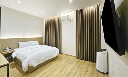 a bedroom with a bed and a flat screen tv at Nobotel Cheonan in Cheonan