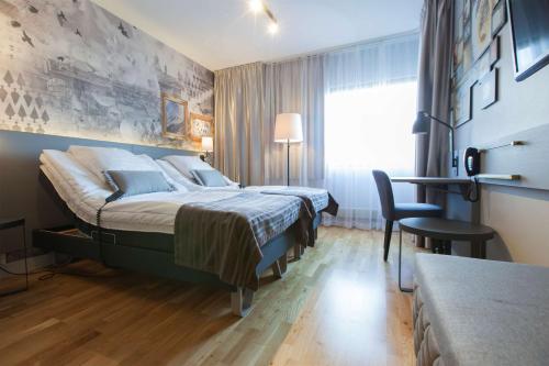 a hotel room with a bed and a desk at Scandic Kuopio in Kuopio