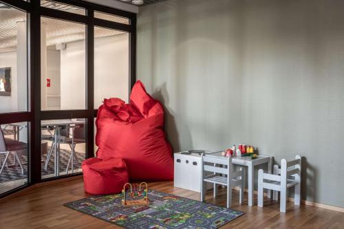 a living room with a red couch and a table at Scandic Kuopio in Kuopio