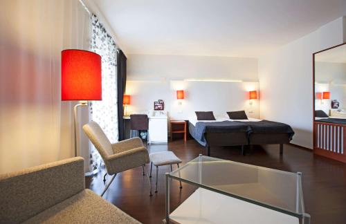 a living room with a couch and a bed and a table at Scandic Patria in Lappeenranta
