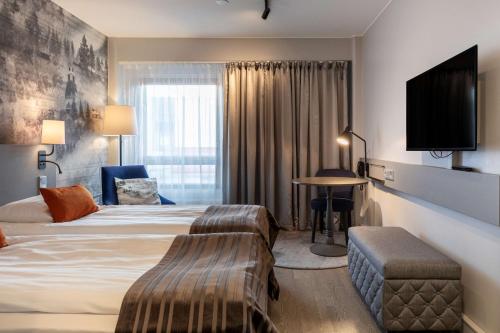 a hotel room with a bed and a tv at Scandic Rovaniemi City in Rovaniemi