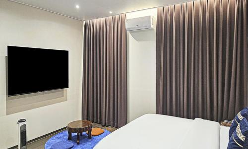 a hotel room with a bed and a television at Nobotel Cheonan in Cheonan