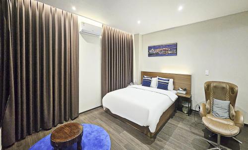 a hotel room with a bed and a chair at Nobotel Cheonan in Cheonan