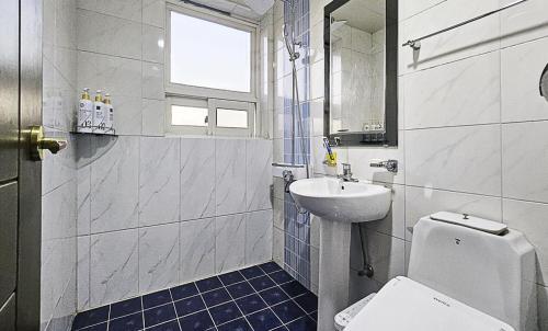 a white bathroom with a sink and a toilet at Nobotel Cheonan in Cheonan