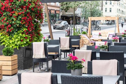 a row of tables and chairs on a street with flowers at Scandic Plaza Turku in Turku