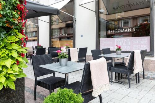 a patio with tables and chairs in front of a store at Scandic Plaza Turku in Turku