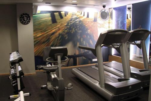 a gym with two tread machines and a painting on the wall at Scandic Plaza Turku in Turku