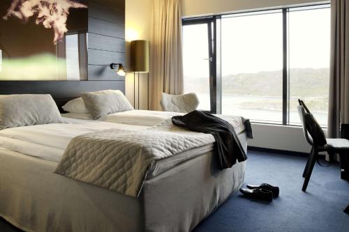 a hotel room with two beds and a large window at Scandic Havet in Bodø