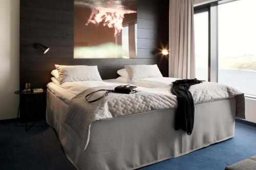 a bedroom with a large bed with a large window at Scandic Havet in Bodø