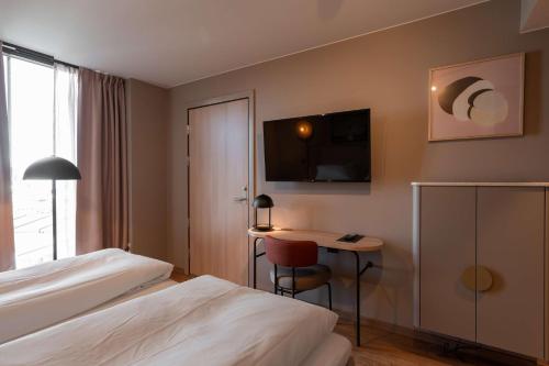 a hotel room with a bed and a desk at Scandic Hamar in Hamar