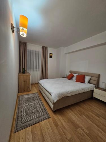 ein Schlafzimmer mit einem großen Bett und Holzböden in der Unterkunft Rin Elegance Apartament in Bukarest