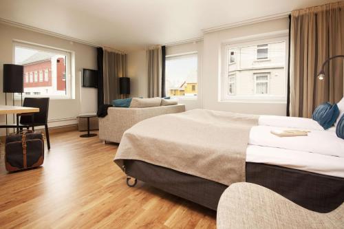 a hotel room with a bed and a couch and a table at Scandic Haugesund in Haugesund