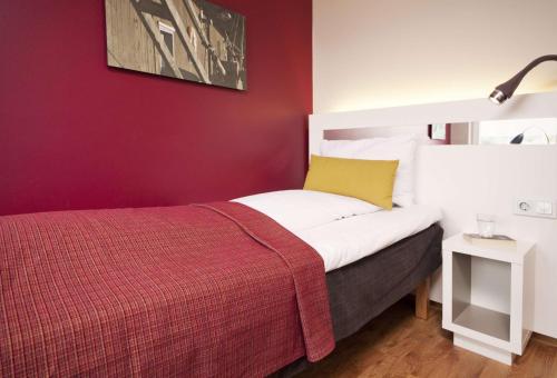 a bedroom with a bed and a red wall at Scandic Haugesund in Haugesund