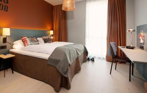 a hotel room with a bed and a desk and a desk at Scandic Kristiansand Bystranda in Kristiansand