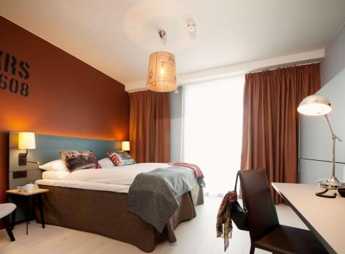 a hotel room with a bed and a desk at Scandic Kristiansand Bystranda in Kristiansand