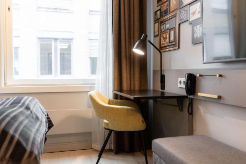 a bedroom with a desk and a bed and a window at Scandic Byporten in Oslo