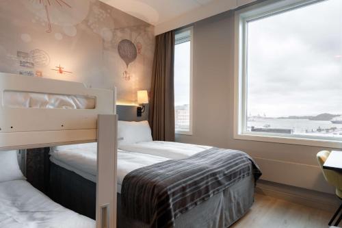 a bedroom with a bed and a large window at Scandic Byporten in Oslo