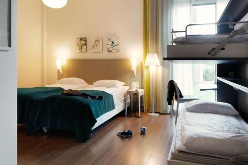 a hotel room with two beds and shoes on the floor at Scandic Oslo Airport in Gardermoen
