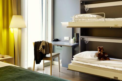 a bedroom with a bunk bed with a chair and a desk at Scandic Oslo Airport in Gardermoen