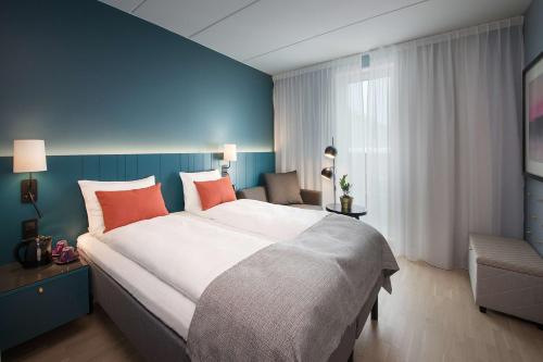 a bedroom with a large bed and a blue wall at Scandic Oslo Airport in Gardermoen