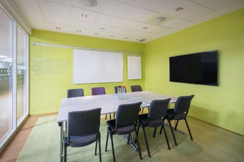 a conference room with a large table and chairs at Scandic Oslo Airport in Gardermoen