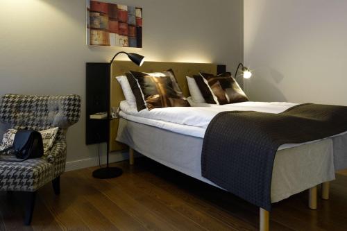 a bedroom with a large bed and a chair at Scandic Stavanger Forus in Stavanger