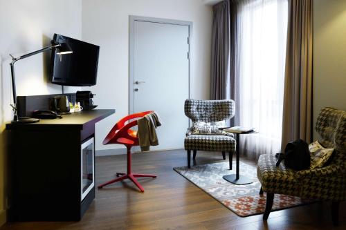 a living room with two chairs and a television at Scandic Stavanger Forus in Stavanger