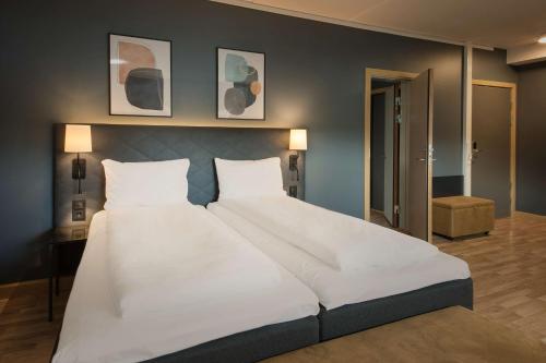 a large white bed in a bedroom with two pillows at Scandic Solsiden in Trondheim