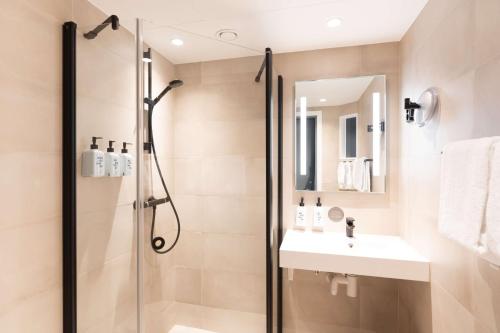 a bathroom with a shower and a sink at Scandic Solsiden in Trondheim
