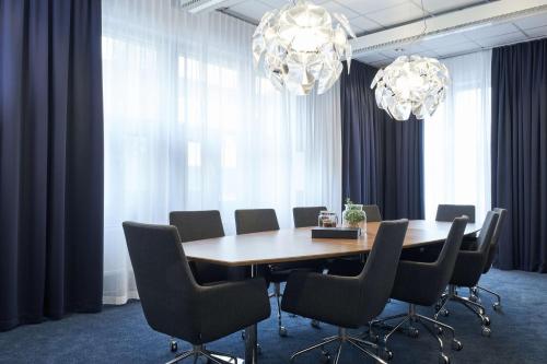 a dining room with a table and chairs and chandeliers at Scandic Crown in Gothenburg